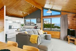a living room with a couch and a kitchen at Modern Townhouse, Stunning Views in Taupo