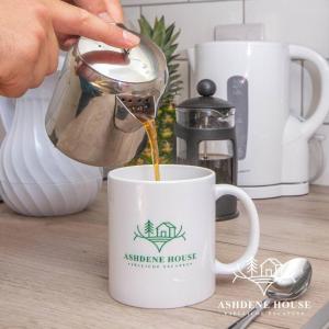 MarchwoodにあるDeluxe 6 - Single - New Forestの白いコーヒーマグにコーヒーを注いでいる人