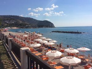 een strand met stoelen en parasols en de oceaan bij La Rotonda in Mattinata