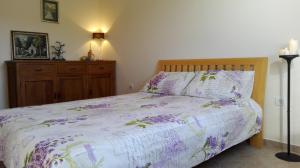 a bedroom with a bed with purple flowers on it at Аpartament Blue Line in Bigovo