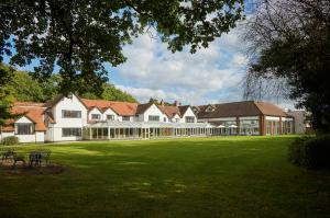 a large building with a large yard with green grass at Macdonald Craxton Wood Hotel & Spa in Ledsham