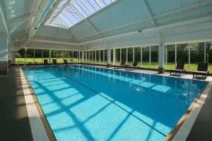 a large swimming pool with a glass ceiling at Macdonald Craxton Wood Hotel & Spa, Chester in Ledsham
