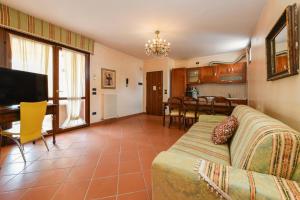 a living room with a couch and a dining room at Prestige Apartment in Sirmione