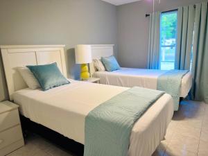 a bedroom with two beds and a window at Main Villa 15 mins from Theme Parks & MCO in Kissimmee +24 photos
