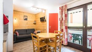une pièce avec une table, des chaises et un canapé dans l'établissement Grande Neige N 10 - 2P4, à Morillon 3 autres photos