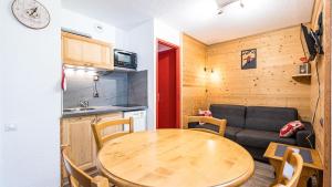 une cuisine et une table dans une petite pièce avec un canapé dans l'établissement Grande Neige N 10 - 2P4, à Morillon