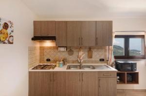 a kitchen with wooden cabinets and a sink at Prima Luce in Vico Equense +32 photos