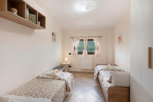 a bedroom with two beds and a window at Prima Luce in Vico Equense