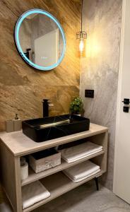 Un baño con un lavabo negro y un espejo. en Noble Stay, en Saturn