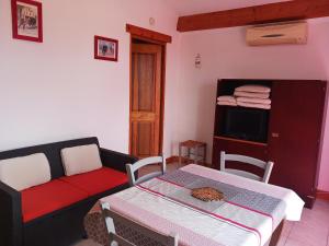 a living room with a couch and a table at Maisonnette avec jardin - Séjour détente in Sabran