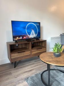 a flat screen tv sitting on top of a wooden entertainment center at Near Old Trafford & Media City 2BR Flat in Manchester