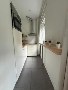 a small kitchen with white walls and a hallway at Green botanical studio 3 in Liège
