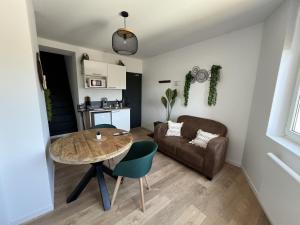 a living room with a table and a couch at Le Jardin Botanique in Lens