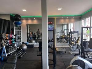 a gym with lots of equipment and a man in the background at Palace Hotel in Cristalina