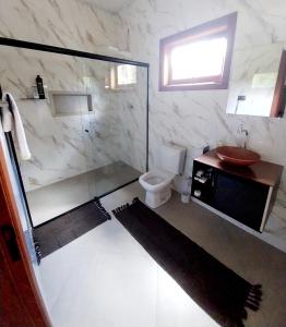 a bathroom with a shower and a toilet and a sink at Chácara 2 coqueiros in Paraisópolis