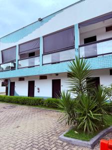 a building with a palm tree in front of it at Hotel Vila dos Pescadores in Aparecida +48 photos