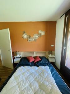 una camera da letto con un letto con due cuscini rossi sopra di Les 3 balcons du Mont Joly a Les Contamines-Montjoie