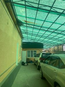 a parking lot with two cars parked in front of a building at Guesthouse IVA in Karakol