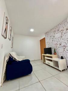 a living room with a blue couch and a tv at Apartamento no térreo para 04 pessoas in Vitória da Conquista