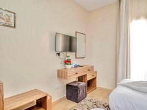 a bedroom with a bed and a television on a wall at Lodge Pyramids View Hotel in Cairo
