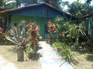 a green house with a pathway in front of it at pousada Rios in Belém