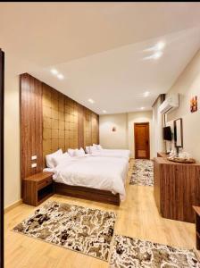 a bedroom with a large white bed and a wooden wall at Lodge Pyramids View Hotel in Cairo