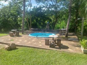 Una piscina con mesa de picnic y un parque infantil. en Chácara PontAlegre, en Rondonópolis