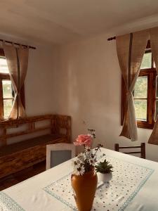 a room with a table with a vase with flowers on it at Dobál Vendégház in Lunca de Sus