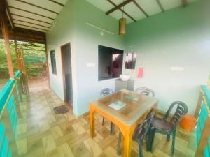 a dining room with a table and chairs at Happydays Hut in Mananthavady