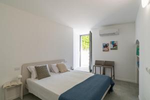 a white bedroom with a bed and a window at GuestHost - Lake View Apartment Villa Maderni Como in Cavallasca +19 photos
