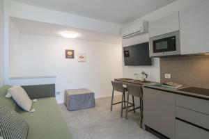 a kitchen and a living room with a couch and a table at GuestHost - Lake View Apartment Villa Maderni Como in Cavallasca
