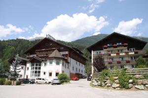 a group of buildings with mountains in the background at Appartementhaus Sporthotel Mölltal in Flattach