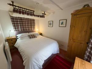 une chambre avec un lit blanc et une fenêtre dans l'établissement Crepigill Cottage, à Portree