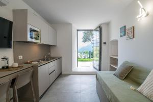 a kitchen and living room with a couch and a window at GuestHost - Lake View Apartment Villa Maderni Como in Cavallasca