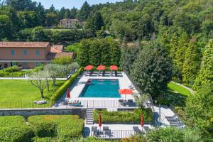 an overhead view of a pool with chairs and umbrellas at GuestHost - Lake View Apartment Villa Maderni Como in Cavallasca