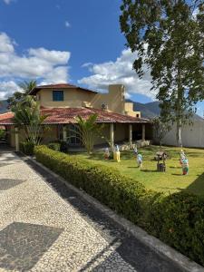 a house with children playing in the yard at Chácara Rbs in Sobral