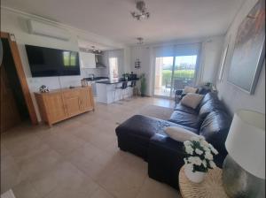 a living room with a blue couch and a kitchen at Beautiful views lake golf house in Roldán