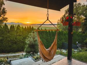 a hammock on a patio with a sunset in the background at Sosnowa 61 in Sosnowa