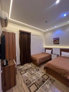 a bedroom with two beds and a flat screen tv at Central Cairo Inn in Cairo