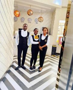 a man and two women standing in a hallway at Olive Ikeja Hotel in Ikeja