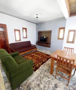 a living room with a couch and a table at Chácara 2 coqueiros in Paraisópolis