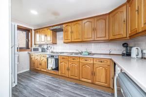 a kitchen with wooden cabinets and a stove top oven at City Centre Apartment in Dunfermline