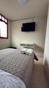 a bedroom with a bed and a tv on the wall at Room in the City Center in Ayacucho