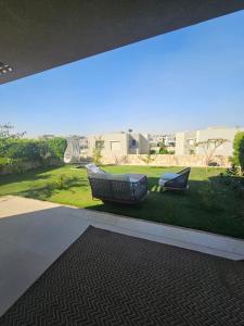 two chairs sitting on the grass in a yard at فيلا Azha بالعين السخنه للعائلات in Ain Sokhna