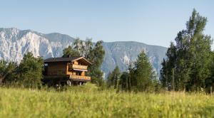 ein Haus auf einem Feld mit Bergen im Hintergrund in der Unterkunft Ferienhaus Oetztal in Sautens