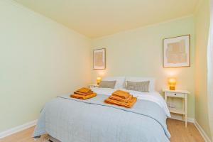 a bedroom with a bed with two towels on it at Fresh, stylish apartment in Sherborne Saint John