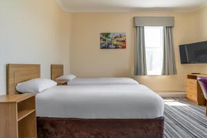 a hotel room with a bed and a television at Norbreck Castle Hotel Blackpool in Blackpool