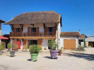 une grande maison avec un balcon et des plantes en pot dans l'établissement Chambre d'hôtes, dauphin, le petit cocon d'auré, à Corbelin