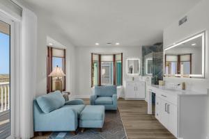 a large bathroom with a blue chair and a sink at The Gulfview Grandeur in Pensacola Beach +68 photos