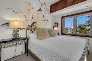 a bedroom with a white bed and a window at The Gulfview Grandeur in Pensacola Beach
